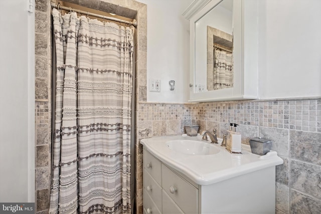 bathroom featuring vanity and tile walls