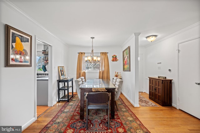 dining room featuring crown molding, a notable chandelier, and light hardwood / wood-style flooring