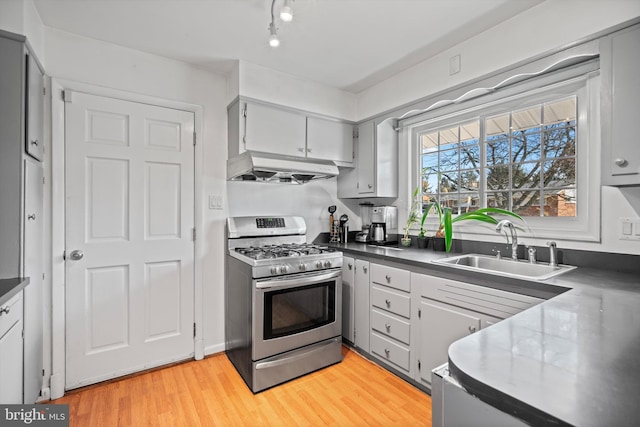 kitchen with sink, gray cabinets, gas stove, and light hardwood / wood-style flooring