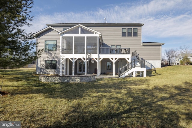 rear view of property with a wooden deck, a lawn, a sunroom, and a patio area