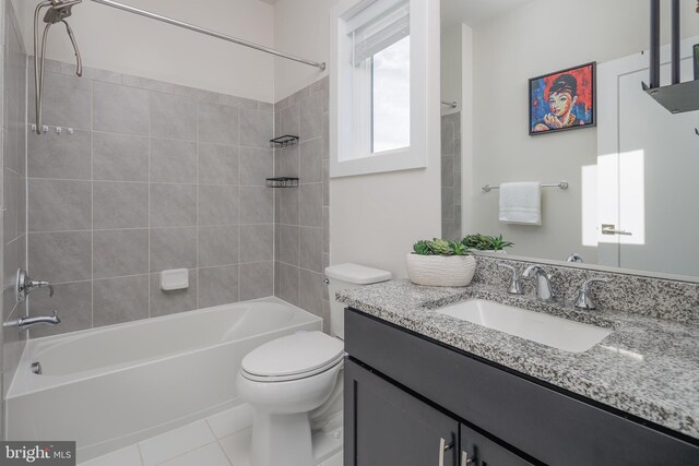 full bathroom with tile patterned flooring, vanity, tiled shower / bath combo, and toilet