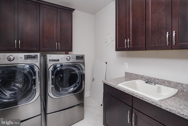 laundry area featuring cabinets, separate washer and dryer, sink, and light tile patterned floors