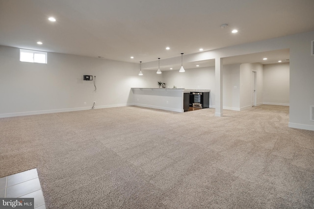 unfurnished living room featuring wine cooler, light colored carpet, and indoor bar