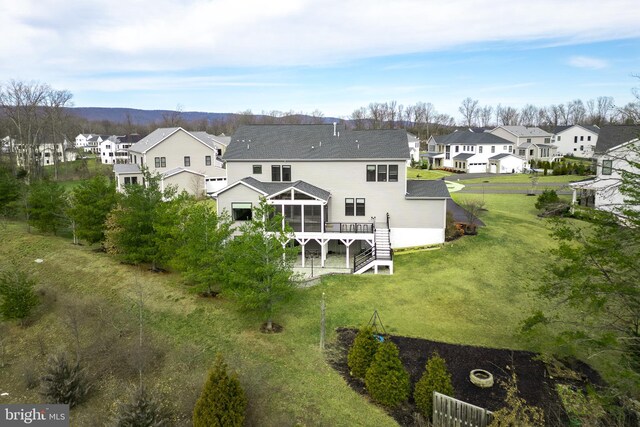 back of property with a sunroom, a yard, and a deck