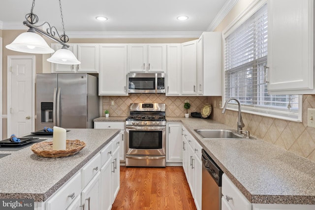 kitchen featuring a kitchen island, decorative light fixtures, white cabinetry, sink, and stainless steel appliances