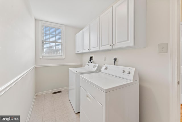 washroom with cabinets and washing machine and dryer