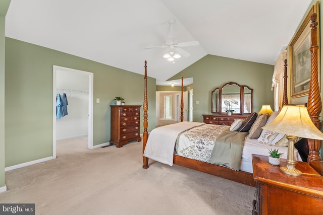 bedroom featuring lofted ceiling, ceiling fan, light carpet, a walk in closet, and a closet