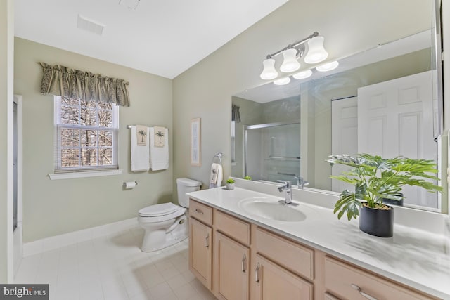 bathroom with a shower with door, vanity, tile patterned flooring, and toilet