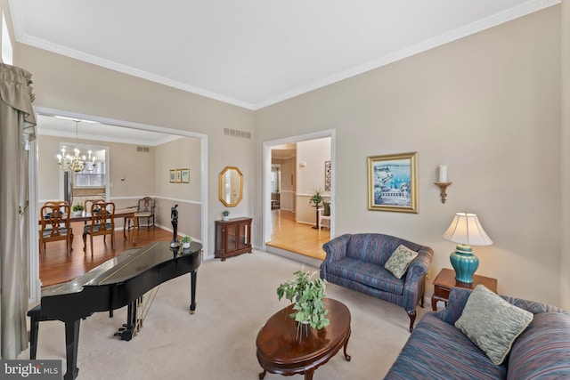 living room with an inviting chandelier, crown molding, and light colored carpet