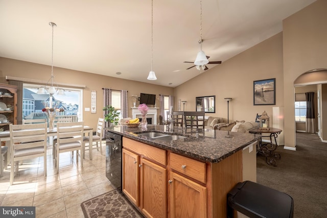 kitchen with decorative light fixtures, black dishwasher, sink, and a center island with sink