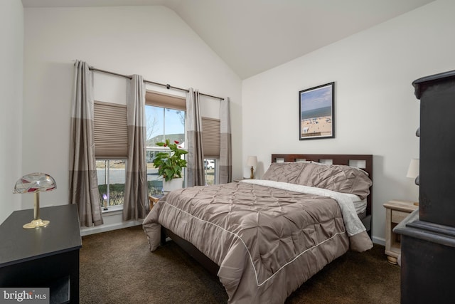 bedroom with dark carpet and vaulted ceiling