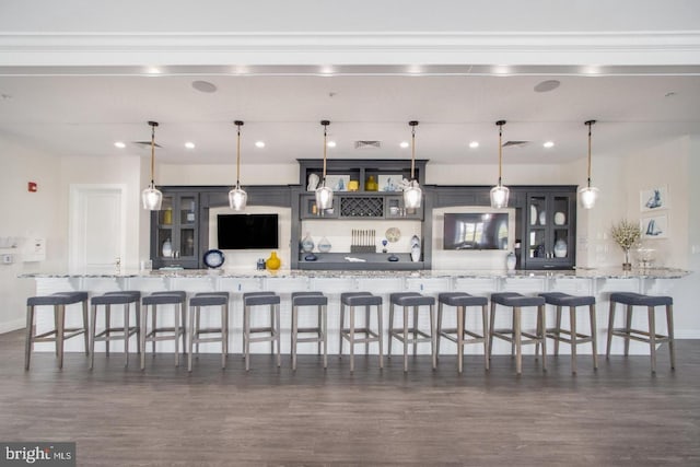 kitchen featuring hanging light fixtures, light stone countertops, and a kitchen breakfast bar