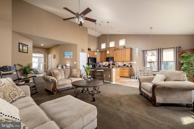 carpeted living room featuring high vaulted ceiling and ceiling fan