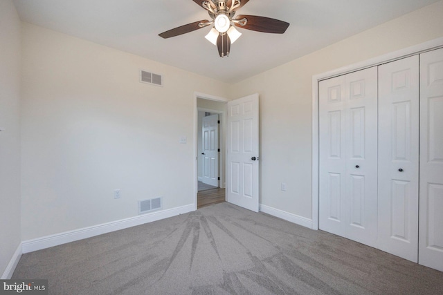 unfurnished bedroom featuring ceiling fan, light colored carpet, and a closet