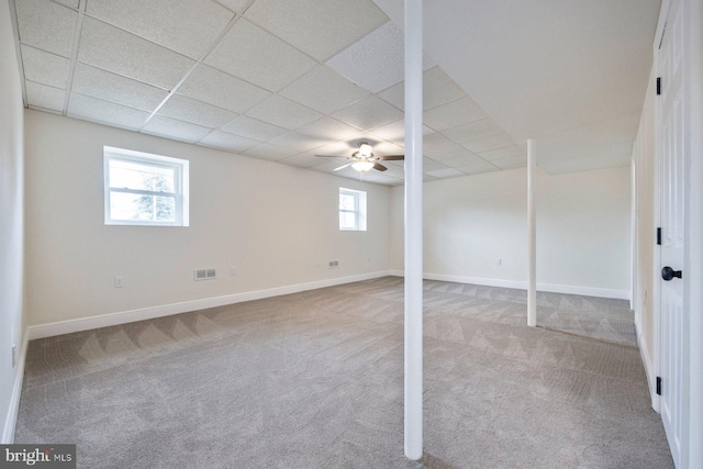 basement featuring ceiling fan, carpet, and a drop ceiling