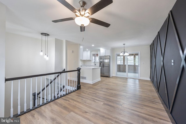 spare room featuring sink, light hardwood / wood-style flooring, and a chandelier