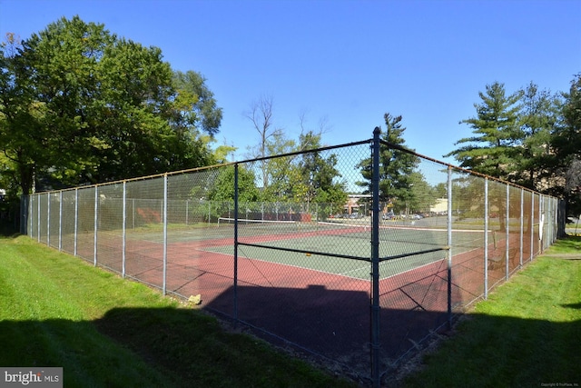 view of tennis court with a lawn