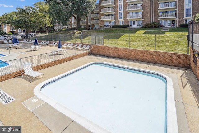 view of swimming pool featuring a lawn and a patio area