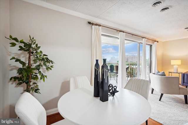 dining space with crown molding and a textured ceiling