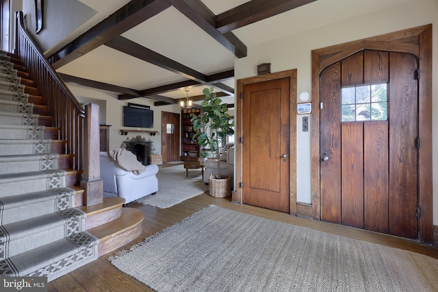 foyer featuring coffered ceiling, wood-type flooring, beamed ceiling, and an inviting chandelier