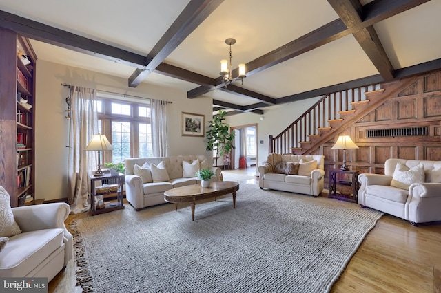 living room with hardwood / wood-style flooring, a chandelier, and beamed ceiling