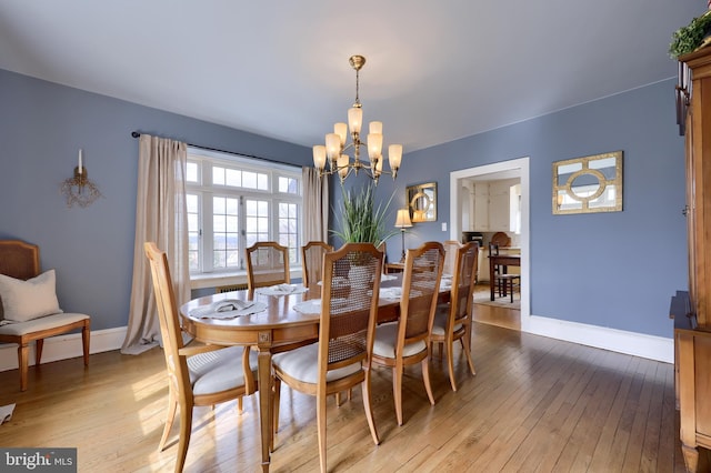 dining space featuring a chandelier and light wood-type flooring