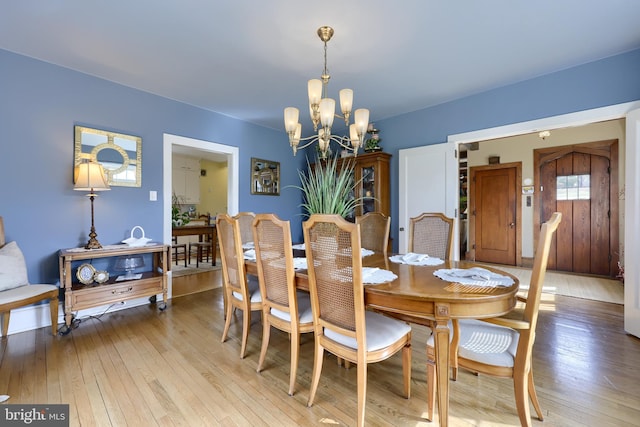 dining room with a chandelier and light hardwood / wood-style floors