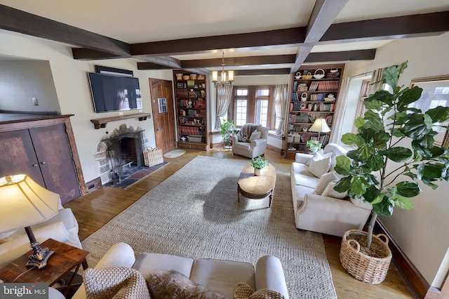 living room with an inviting chandelier, hardwood / wood-style flooring, and beam ceiling