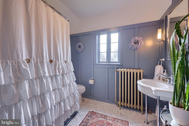 bathroom featuring radiator heating unit and toilet