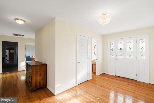 entryway with a notable chandelier and light wood-type flooring