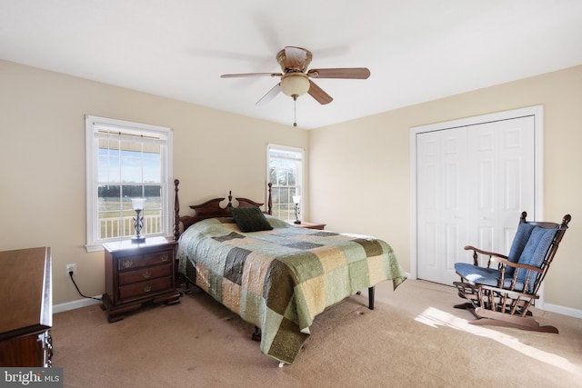 bedroom featuring multiple windows, light colored carpet, a closet, and ceiling fan