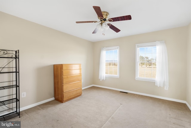 carpeted spare room with ceiling fan