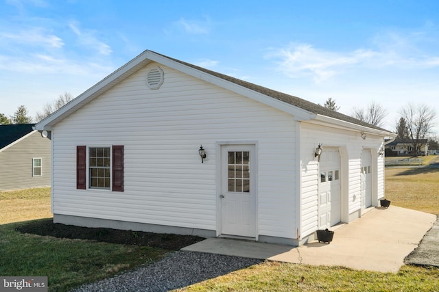 back of property with a yard, a garage, and an outdoor structure