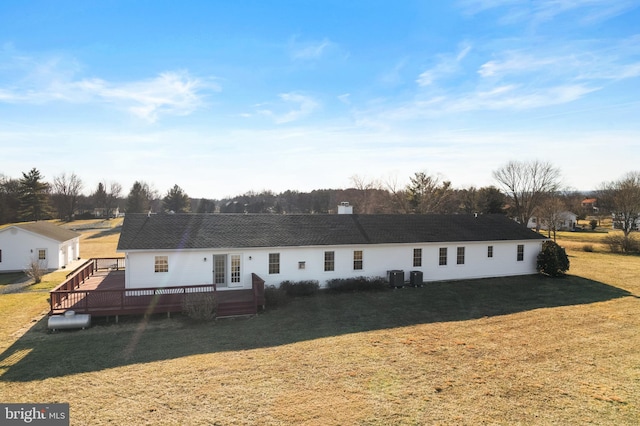 view of front of house with a wooden deck, central AC, and a front yard