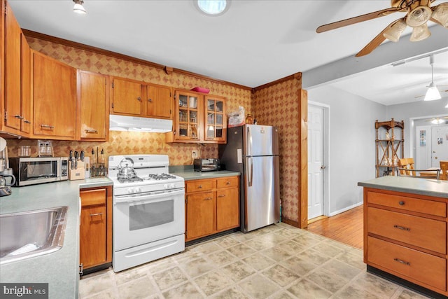 kitchen featuring sink, ceiling fan, appliances with stainless steel finishes, backsplash, and decorative light fixtures