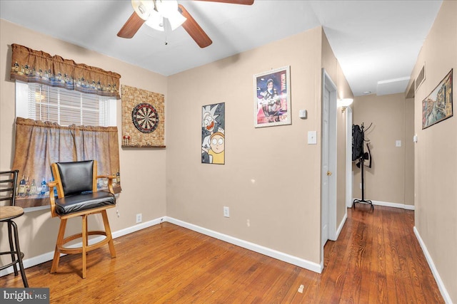 sitting room with hardwood / wood-style floors and ceiling fan