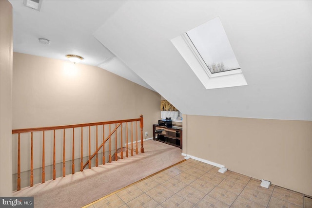 additional living space featuring light colored carpet and lofted ceiling with skylight