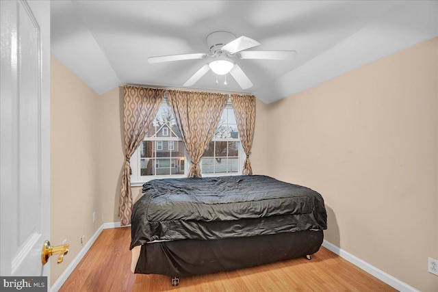 bedroom with lofted ceiling, hardwood / wood-style flooring, and ceiling fan