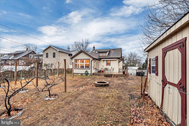 back of house featuring a wooden deck and an outdoor fire pit