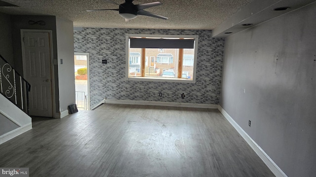 empty room featuring hardwood / wood-style flooring, ceiling fan, and a textured ceiling