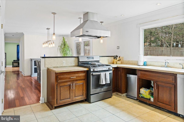 kitchen featuring extractor fan, a sink, light countertops, ornamental molding, and gas range