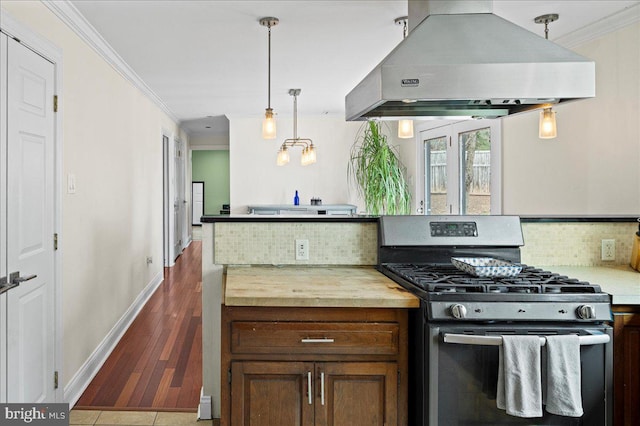 kitchen with stainless steel range with gas cooktop, island exhaust hood, tasteful backsplash, ornamental molding, and dark wood-type flooring