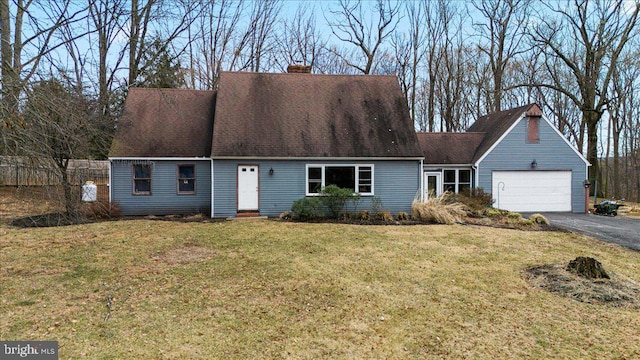 cape cod house featuring aphalt driveway, a garage, a shingled roof, a chimney, and a front yard