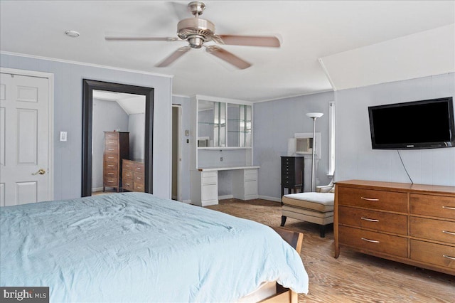 bedroom with ceiling fan, a wall mounted air conditioner, wood finished floors, and crown molding