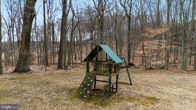 view of yard with a wooded view and a playground