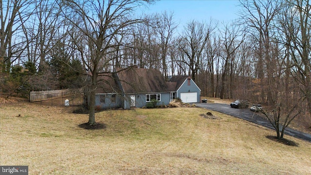 view of front of property featuring driveway, a garage, and a front lawn