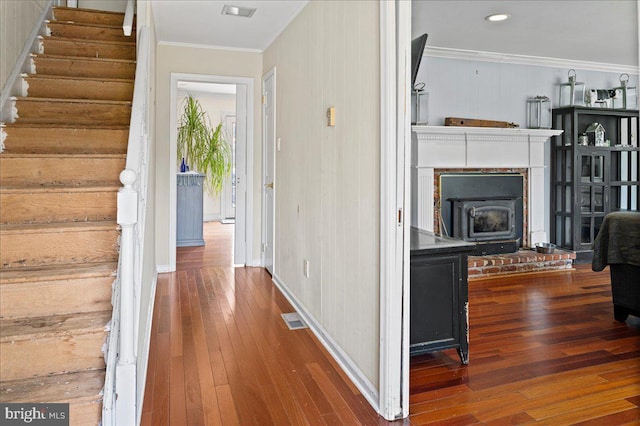 corridor featuring stairs, hardwood / wood-style flooring, visible vents, and crown molding