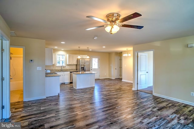 unfurnished living room featuring ceiling fan, dark hardwood / wood-style floors, and sink