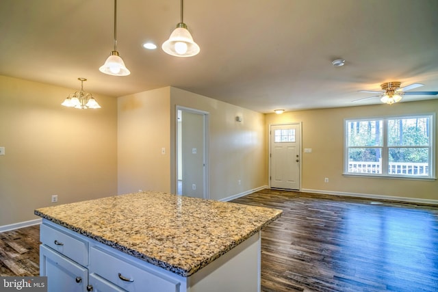 kitchen featuring pendant lighting, dark hardwood / wood-style floors, a center island, white cabinets, and ceiling fan with notable chandelier