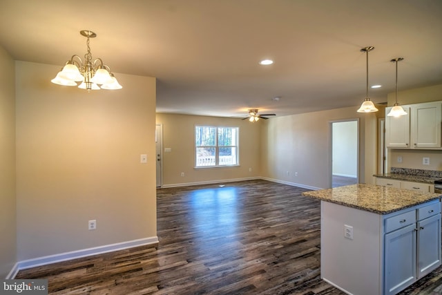 kitchen featuring decorative light fixtures, ceiling fan with notable chandelier, light stone countertops, and white cabinets